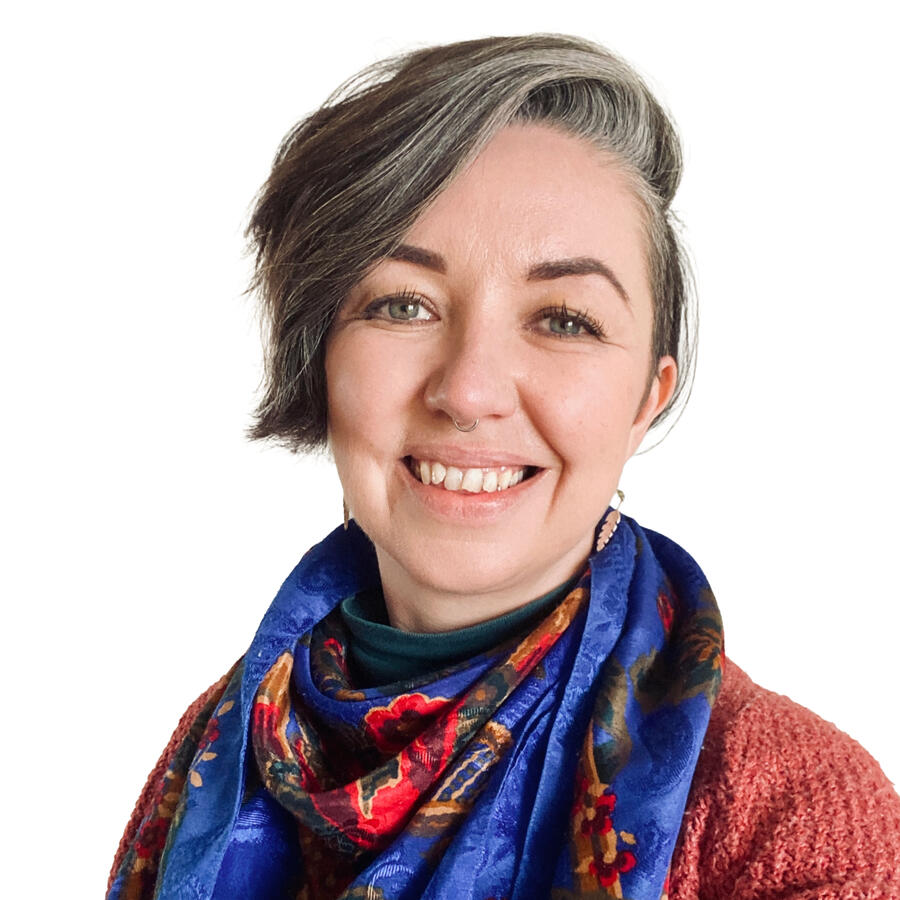 Head and shoulders of a counsellor with short hair hair and blue scarf.